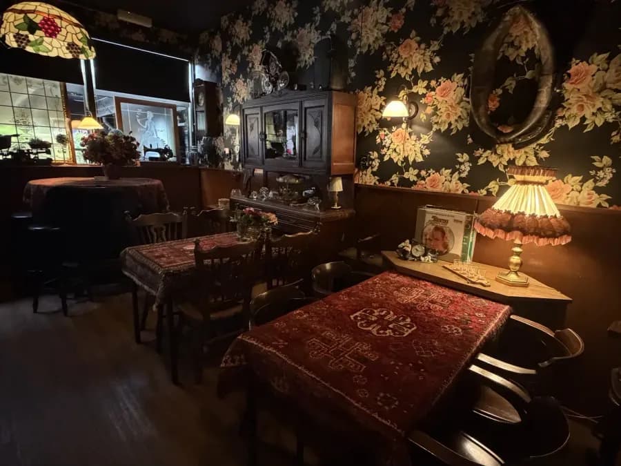 De stamtafel met Perzisch kleed en bloemenbehang
